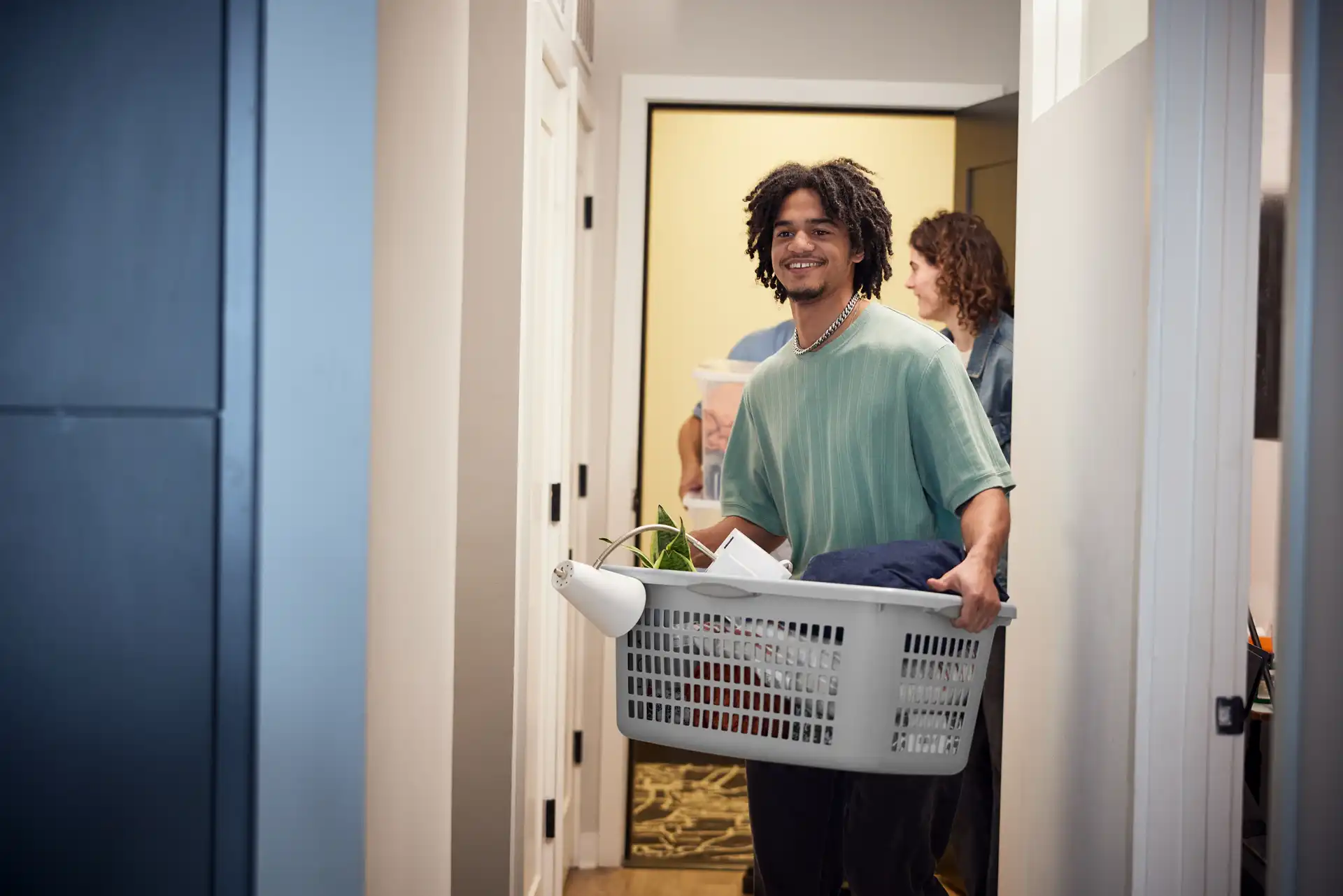 A college student moves his personal items into a dorm room.