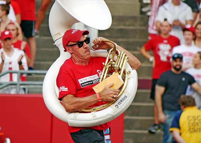 A photo showing a member of the UW Madison Alumni Band playing the tuba. 