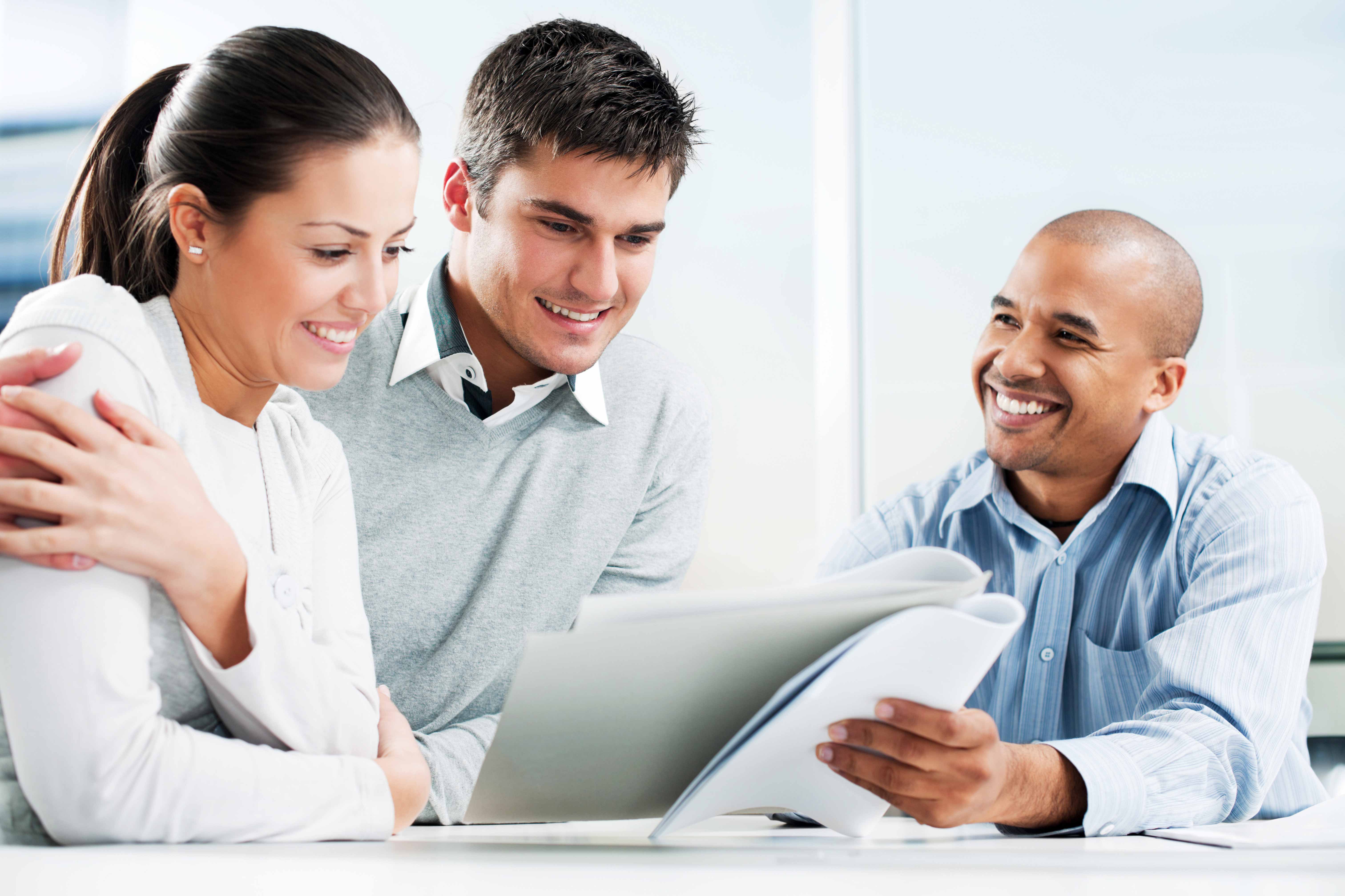 Couple reviews paperwork with a mortgage loan officer.